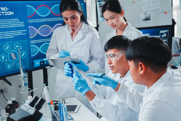 A team of scientists in a modern lab analyzing test tubes with blue liquids. They collaborate, record data, and examine results, highlighting teamwork, research, and scientific precision.