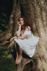 Woman in a White Dress is walking in a park, soft-focus trendy image. 