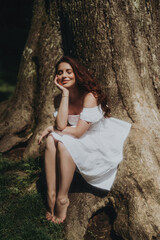 Naklejka premium Woman in a White Dress is walking in a park, soft-focus trendy image. 