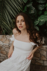 Fototapeta premium Woman in a White Dress is walking in a park, soft-focus trendy image. 