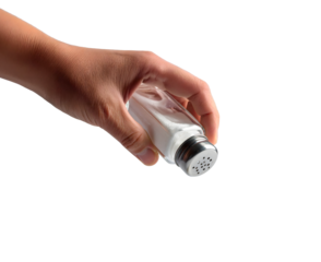 Hand sprinkling salt from a shaker.