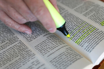 Man studying the Bible and highlighting important passages. Bible study.
