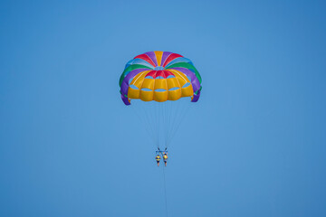 tourists parasailing on a sea seen against the clear blue sky