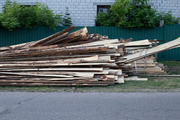 Pile of Rough Wood Boards at Street for Building