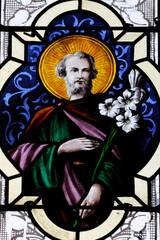 Fototapeta premium Saint Marien church. Stained glass. Saint Joseph with a white lily. Mezilles. France.