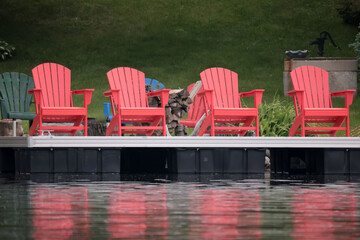 Four red summer plastic chairs on dock