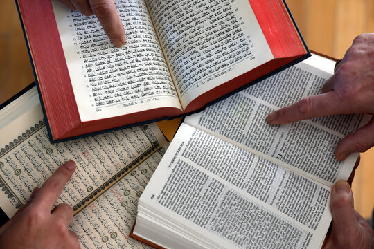 Three monotheistic religions. A Christian, a Jew, and a Muslim reading the Bible, the Torah, and the Quran. Symbol of peace and interfaith dialogue.