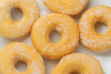 Sugar sprinkles donuts on white plate. Top view