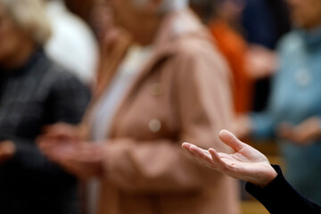 Catholic  church. Faithful praying during Sunday mass.Close up on hands. Prayer of Our Father. Saint Pierre et Paul church.  Saint Julien en Genevois. France.