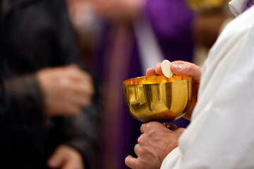 Catholic church. Sunday mass. Priest giving Holy Communion. Saint Pierre et Paul church.  Saint Julien en Genevois. France.