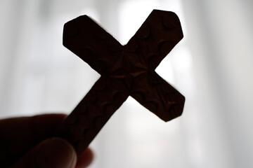 Silhouette of a Christian cross in backlight. Symbol of prayer.