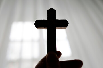 Silhouette of a Christian cross in backlight. Symbol of prayer.