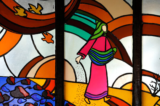 Kon Tum Cathedral.   Stained glass window. The parable of the sower of seed. A man went out to sow grain. The man represents God and the seed is His message.  Kontum. Vietnam.