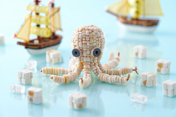 Adorable beaded octopus figurine with miniature ships and cubes
