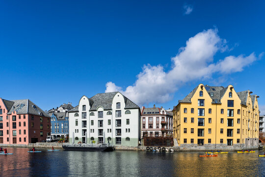 Colorful Waterfront Houses with Recreational Activity Under Clear Blue Sky, Aalesund, Norway
