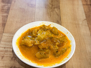 A plate of Gulai Urat Tunjang, a rich Indonesian curry made with slow-cooked beef leg tendons in a spiced coconut milk sauce. 