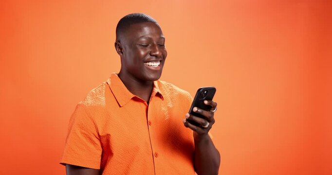 Surprise, cellphone and black man in studio, sunglasses and fraud email on orange background. African person, wow and model with smartphone, shades and shocked with message, scam and announcement