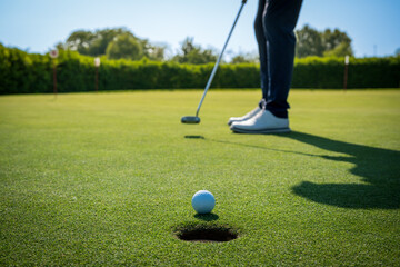 Golfer putting ball close to hole on green golf course