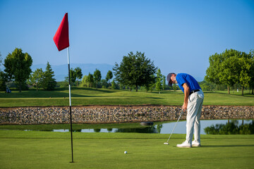 Golfer putting the ball on the green of a beautiful golf course