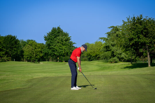 Golfer preparing to swing on a sunny day at the golf course - Powered by Adobe
