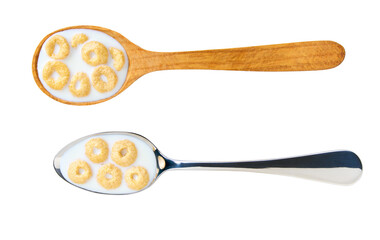 Whole grain cereal rings with milk in a metal spoon isolated on white background, top view.