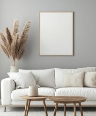 Modern minimalist living room featuring a blank framed canvas, light beige and white furniture, and natural elements