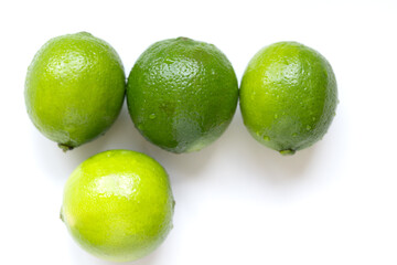 Fresh, vibrant green limes on a clean white surface. Juicy citrus fruits symbolizing summer freshness and healthy living. Selective focus creates a bright, inviting mood.