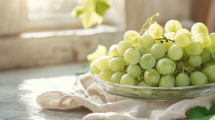 Delicious green grapes glistening in sunlight are arranged neatly in a glass bowl, capturing the allure of this fresh fruit and its wholesome appeal in a natural light setting.