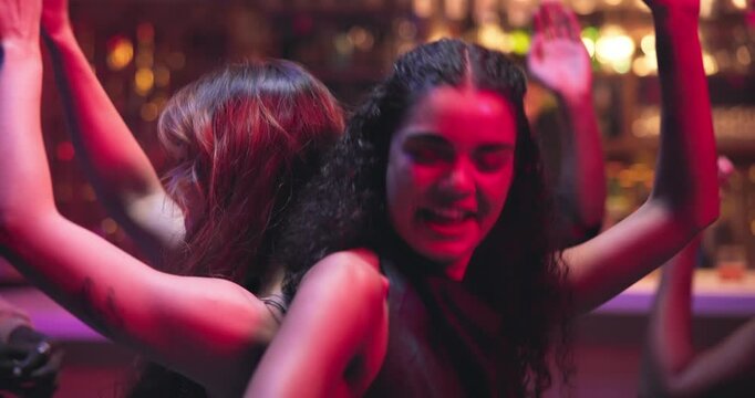 Smile, women and friends dancing at nightclub with energy, movement and rhythm at disco event. People, laugh and reunion for New Years celebration, music festival and freedom by bonding for nightlife