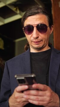 This footage conveys a focused and engaged mood, depicting a person intently looking down at their smartphone, ideal for illustrating digital communication, online work, or personal device usage
