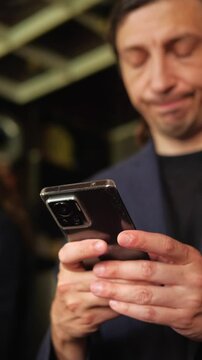 This footage conveys a focused and engaged mood, depicting a person intently looking down at their smartphone, ideal for illustrating digital communication, online work, or personal device usage