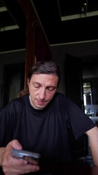 This footage conveys a pensive and concerned mood, depicting a person looking down at a smartphone with a hand near their face, suggesting a moment of serious contemplation