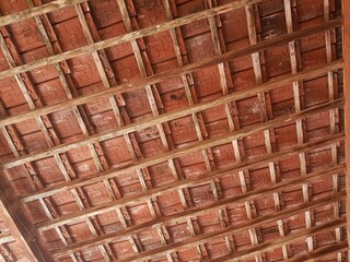 Traditional clay tile ceiling with wooden beams. Rustic, earthy tones. Architectural detail,...