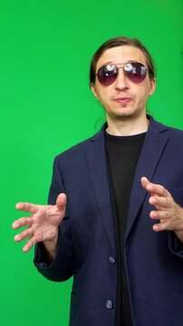 A mid-shot captures an energetic and motivational mood as a man in a suit jacket and sunglasses gestures expressively while speaking, ideal for impactful business or inspirational content