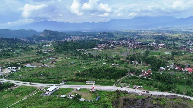 West Java, Indonesia - April 8, 2025: Aerial view drone shot of traffic near Shooting Training Center PLP Monument and village in Garut
