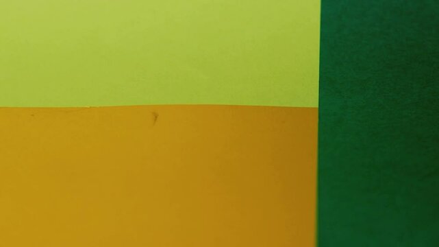 Vivid construction paper backgrounds in bold colors are gently animated by soft, natural shadows gliding across the surface, creating depth, movement, and visual warmth.