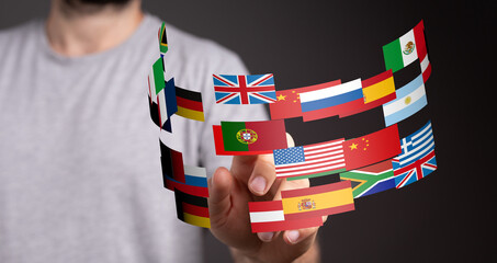 Image of a person interacting with a digital display of various national flags, representing global...
