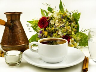 Coffee in a cezve and in a cup, a glass of water, salt, cinnamon. Coffee and various additions to it.
