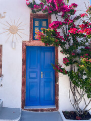 blue door and flowers in santorini greece