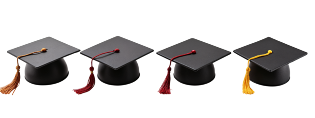 A set of four black graduation hats with tassels on them.