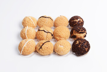 A dozen of mini cream puffs, light airy pastries made from choux dough and filled with sweet cream or custard. They have a crispy, golden brown shell, drizzled with white and dark chocolate icing.