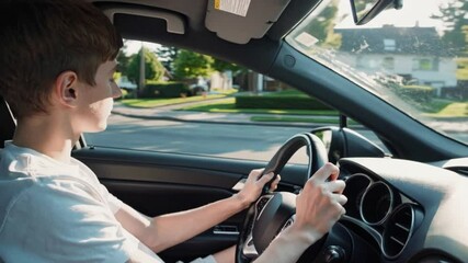 Young teenager boy driving his car for the first time. Young boy driving in a car.