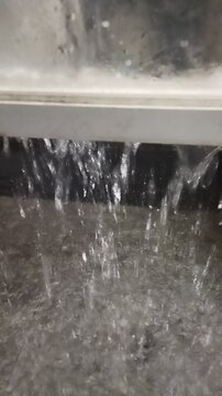Heavy Rain Falling Below Window and Flooding Backyard Floor