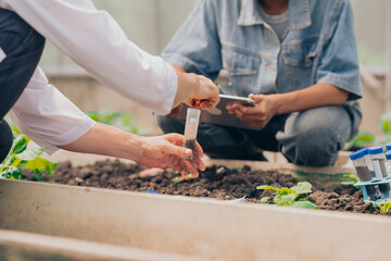 Teachers and students test and research soil for agriculture, farming, and cultivation in...