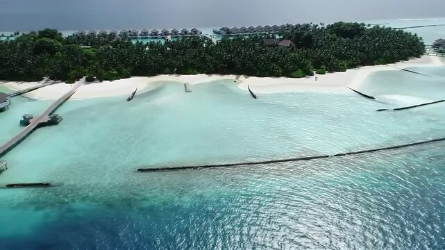 A cinematic aerial video from an absolute top-down drone perspective flying over a luxurious tropical island resort in the Maldives.