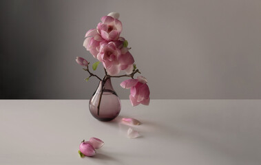 magnolia wreath in glass vase on wall background