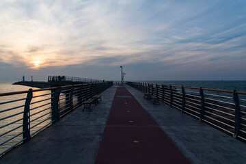 walkway on the seawall at the harbor during sunset
