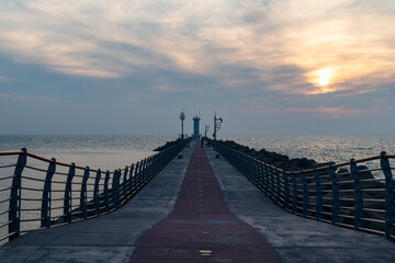 Obraz premium walkway on the seawall at the harbor during sunset