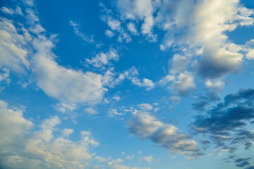  Sky with scattered clouds illuminated by golden light, with the setting sun behind the horizon.