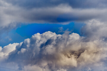 Smooth lines of Cumulus clouds create a sense of movement and perspective. The image symbolizes a journey, travel, distance, and dreams.